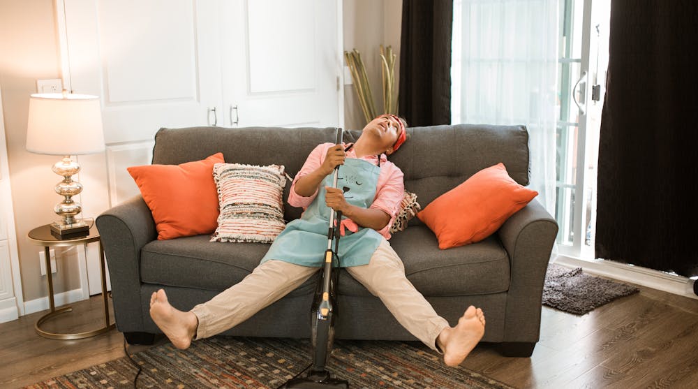 A tired man resting after vacuuming the carpets